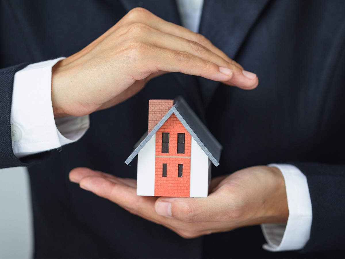 A house model in the hands of a businessman. 