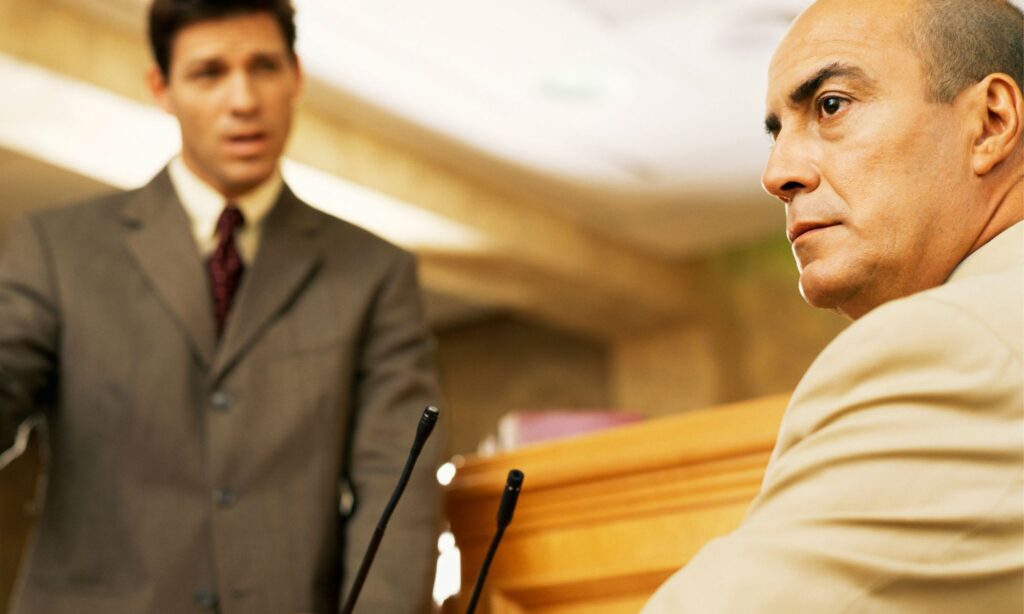 man sitting in witness stand in court