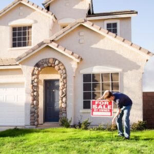 man installing for sale by owner sign