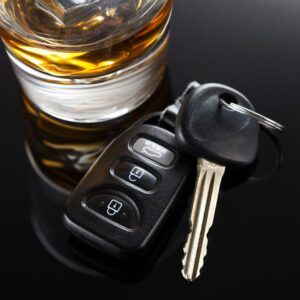 A glass of alcohol next to car keys