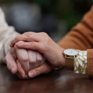 A hand holding another hand for support