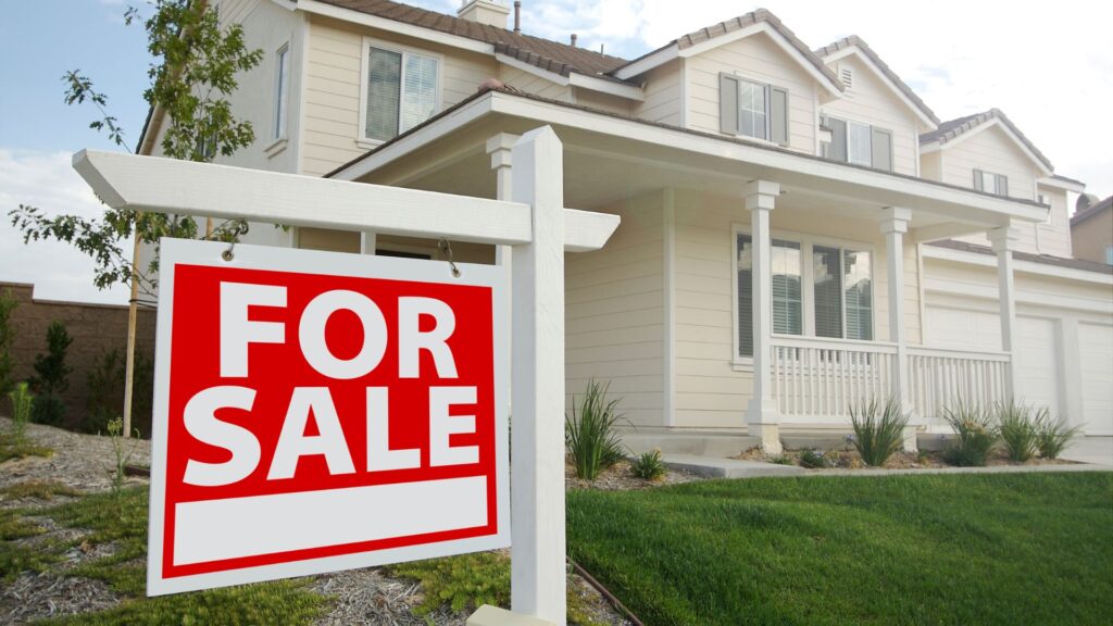 Home with a for sale sign in the front yard