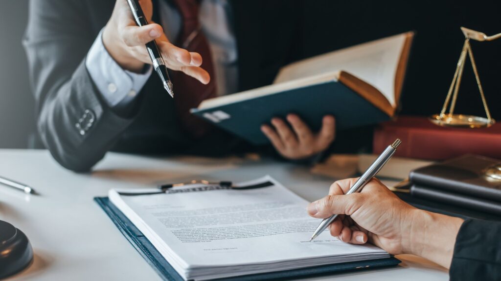 two lawyers looking at a contract and a law book