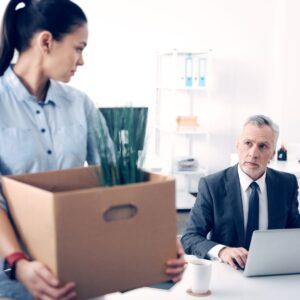 a women with her desk packed up looking at her boss