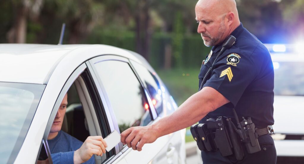 Police officer taking license from driver