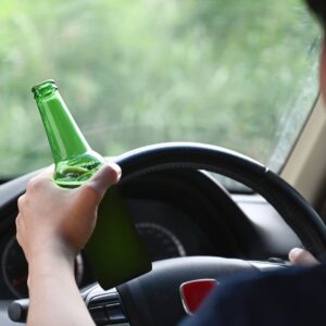 Person driving with beer in hand