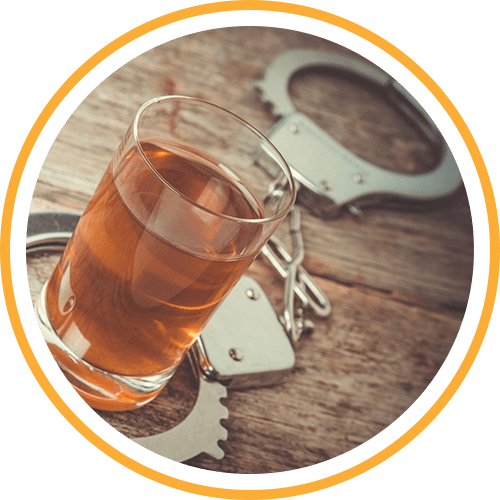 handcuffs around a shot of alcohol