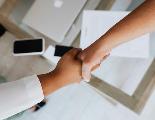 Overhead view of a professional handshake over legal documents.