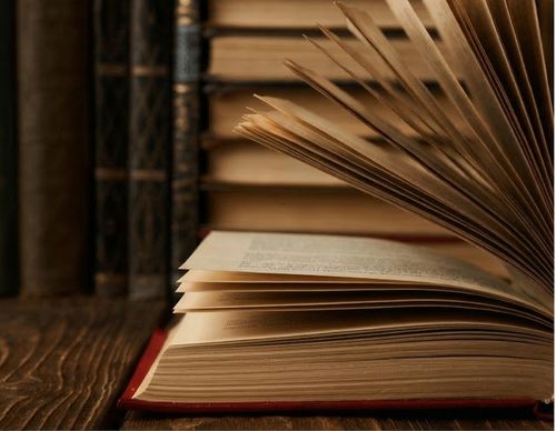Open law books with pages turning on a desk.