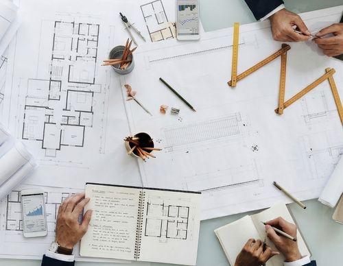 Aerial view of architectural blueprints and drafting tools.