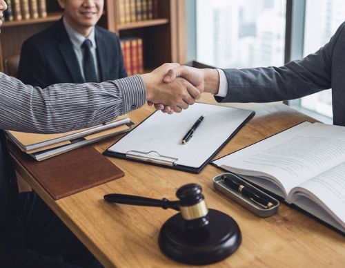 Client and lawyer shaking hands during a legal consultation