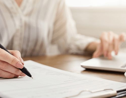 Person signing a legal employment document at a desk.