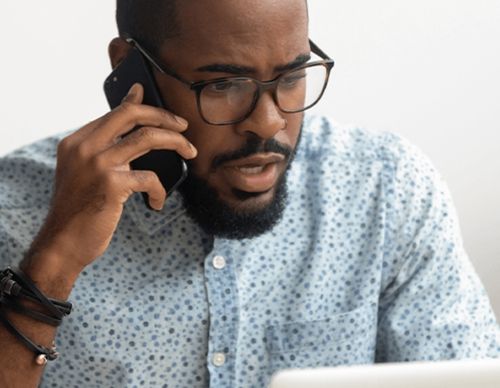 Man with glasses talking on his mobile phone.