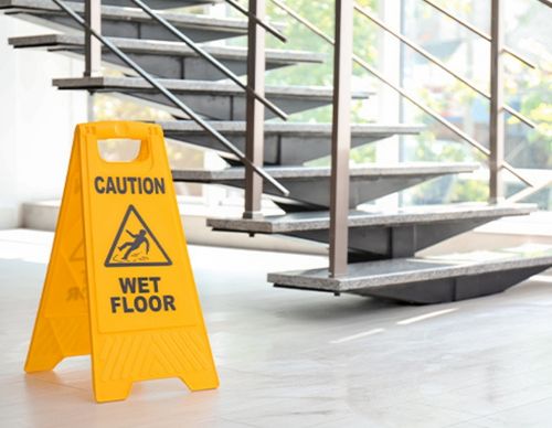 Yellow "Caution Wet Floor" sign near a staircase.
