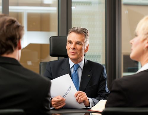 Professional businessman leading a meeting in a glass office