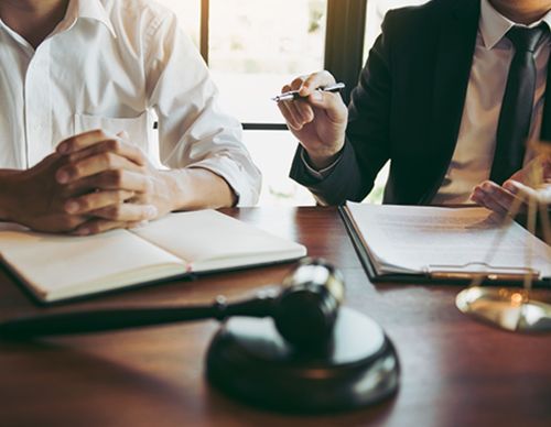 Client and lawyer discussing case details in an office.