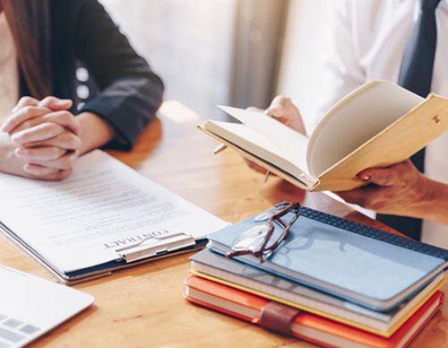 Attorney reviewing a contract during a client meeting.