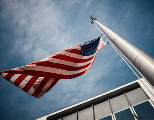 Low-angle view of the American flag waving on a pole.