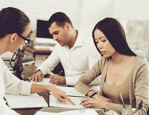 Lawyer and couple reviewing documents in a law office.