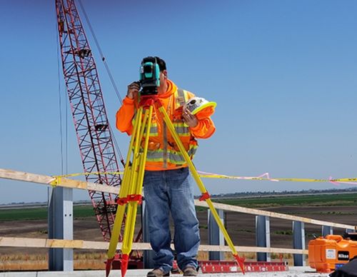 Construction surveyor using a total station on a job site