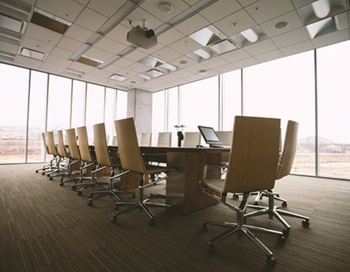 Empty modern boardroom with long table and city view