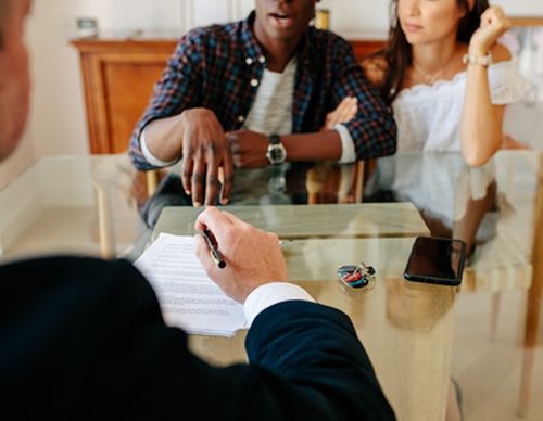 Close-up of a legal contract signing with a couple.
