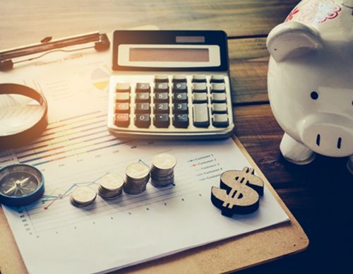 Financial planning layout with calculator, coins, and piggy bank.