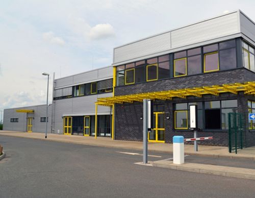 Modern industrial office building with yellow accents.