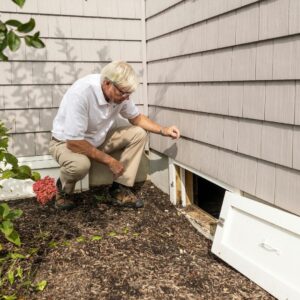 Home inspector examining a coastal Florida house crawl space for structural and moisture issues prior to contract finalization.