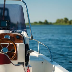 Close-up of a boat steering wheel and dashboard helm on a river, illustrating captain responsibility and maritime regulations.